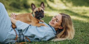 Young woman with her pet french bulldog in park